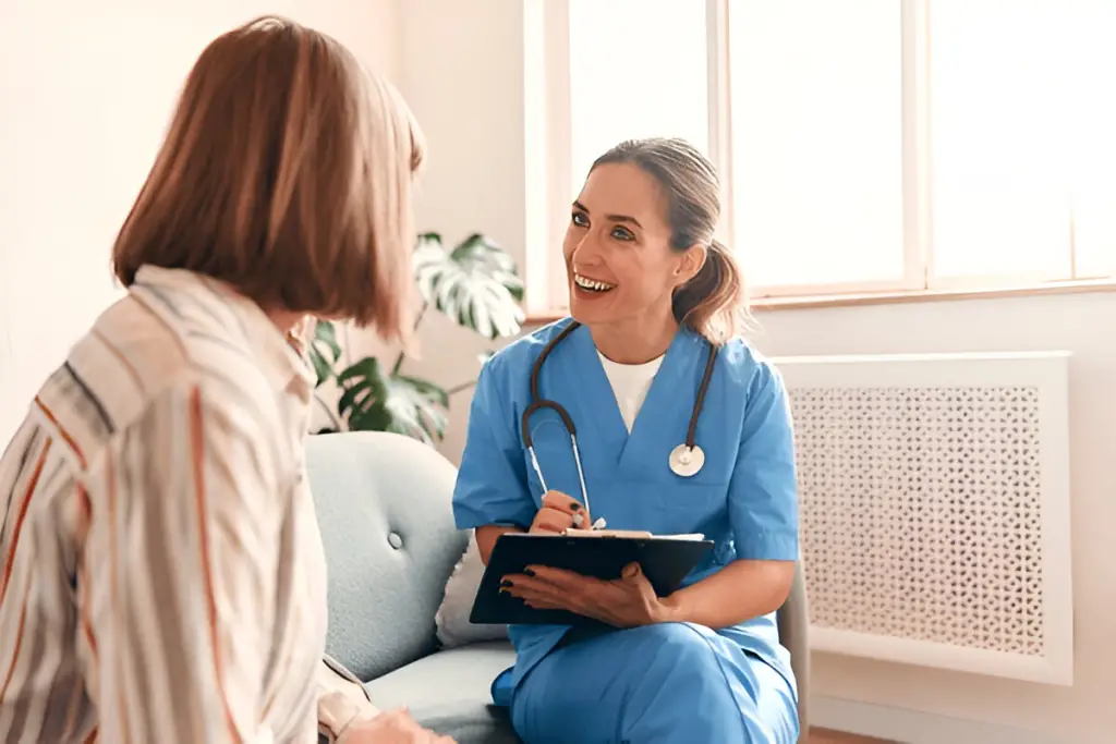 Smiling nurse talks to patient.