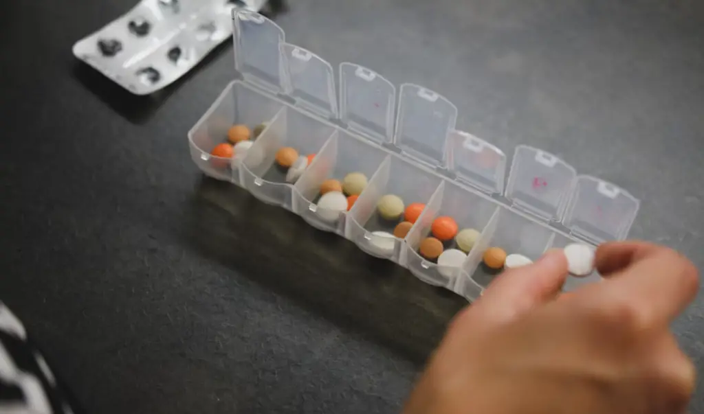 Hand putting pill in dispenser