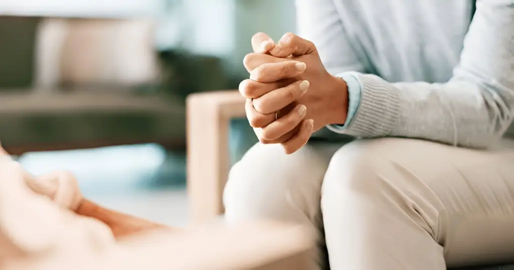 Close-up of anxious, clasped hands.