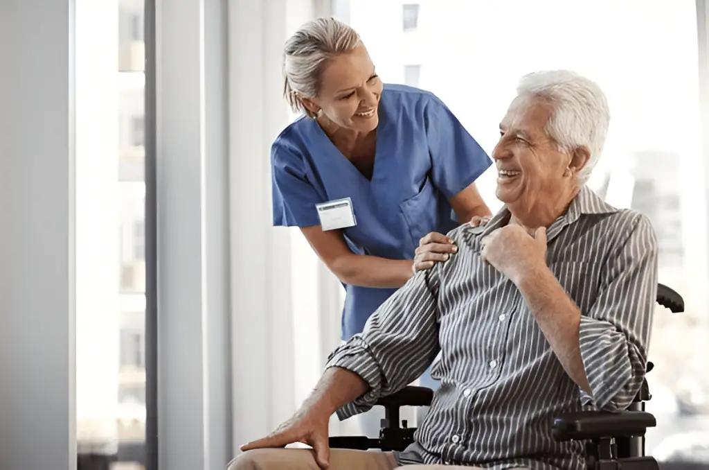 Nurse and smiling man in wheelchair.