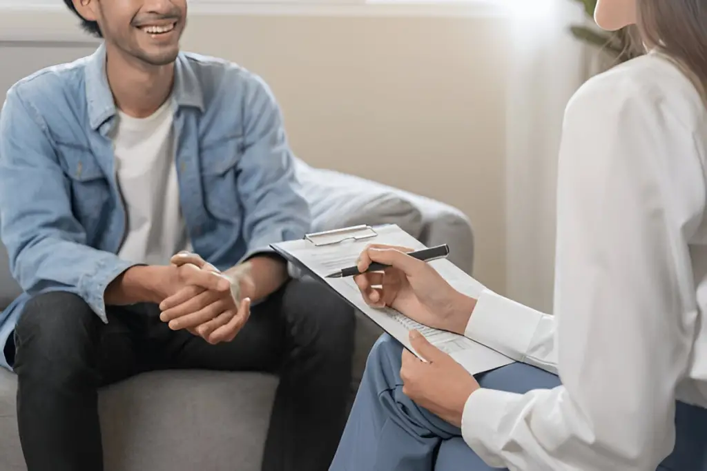 Smiling man meets with counselor.