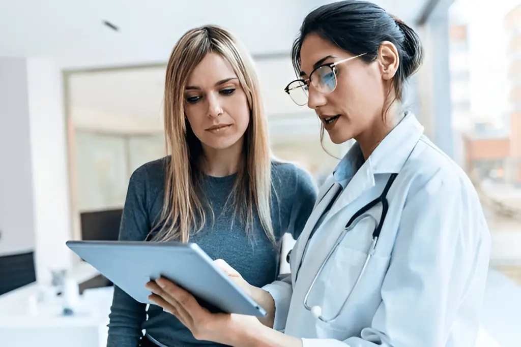 Female doctor showing patient a tablet.