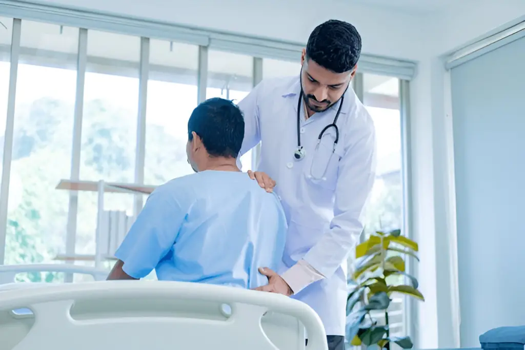 Doctor helps patient sit up.