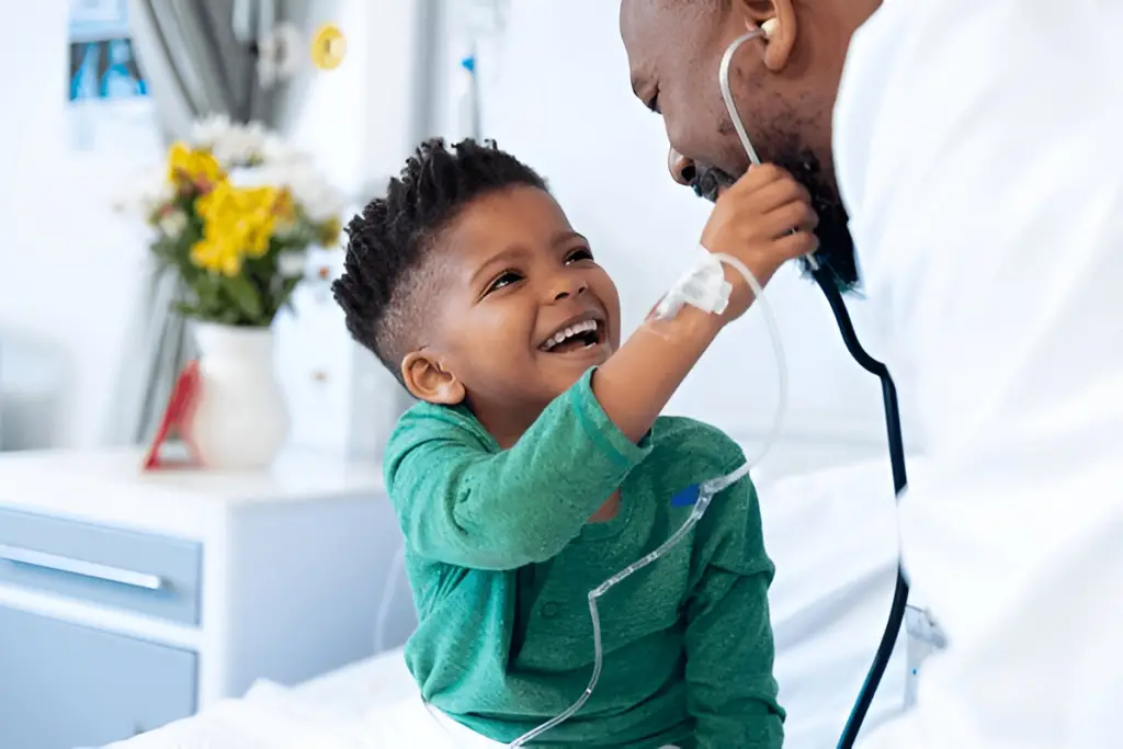 Happy boy plays with doctor's stethoscope.
