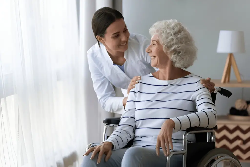 Caregiver talking with senior in wheelchair.