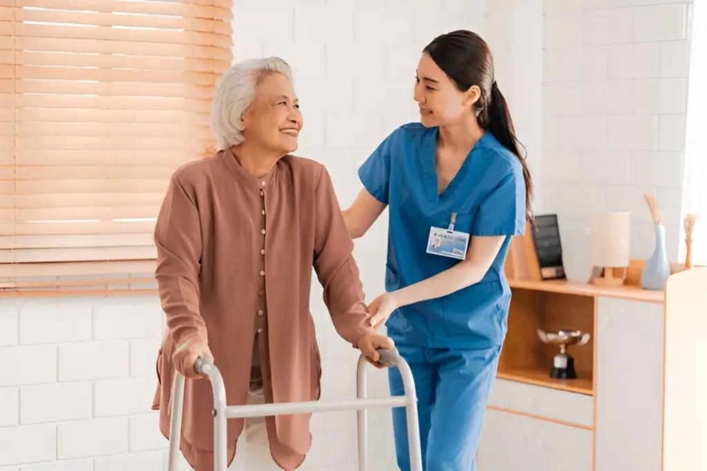 Caregiver helps senior walk with a walker.