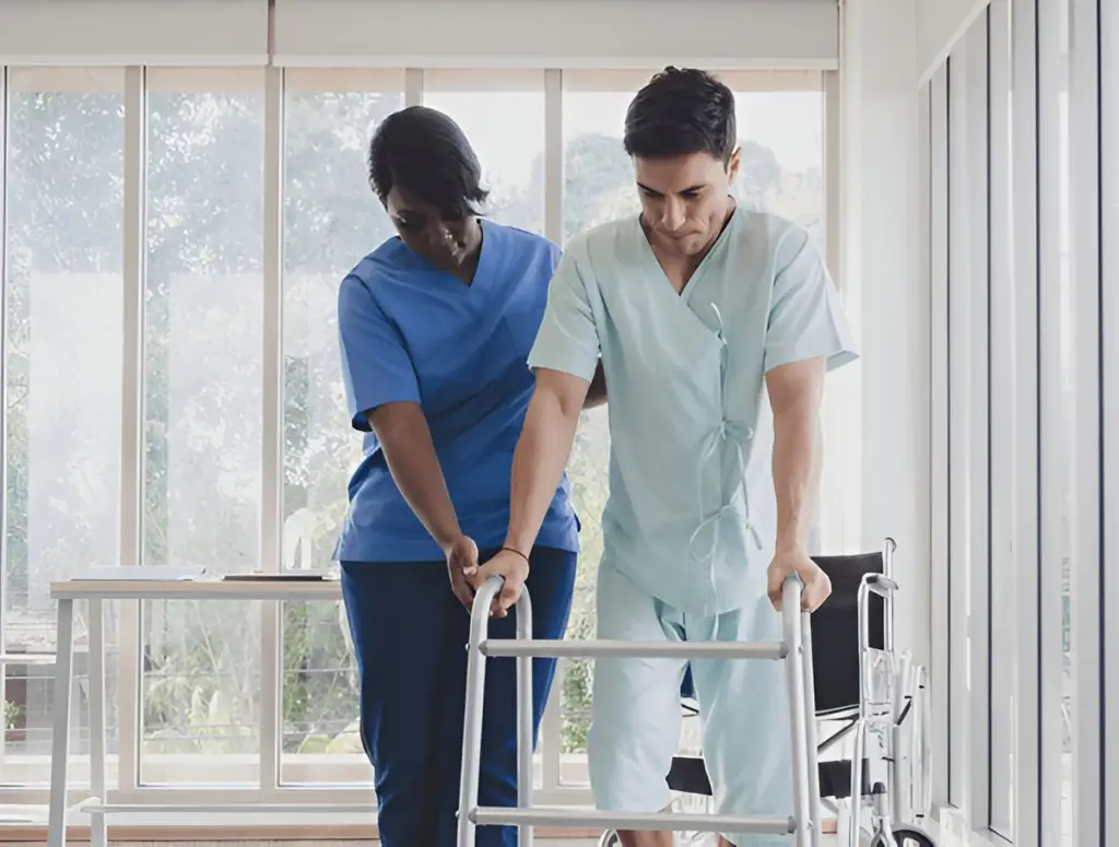 Nurse assists male patient with walker.