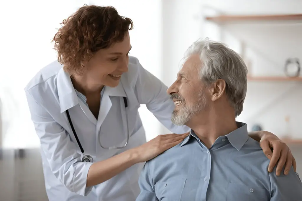 Smiling doctor with hand on patient's shoulder.