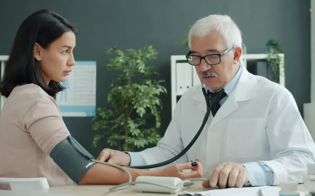 Doctor checking patient's blood pressure.