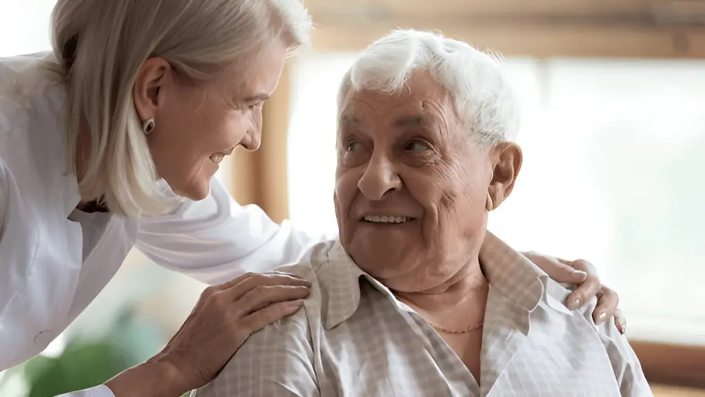 Caregiver smiling with happy senior man.